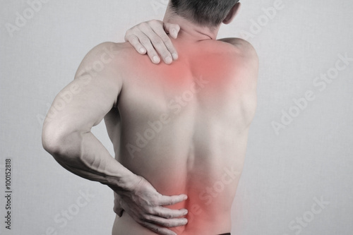Man with neck and back pain. Man rubbing his painful back close up. Pain relief concept photo