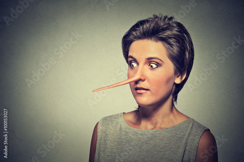 Woman with long nose isolated on grey wall background. Liar concept