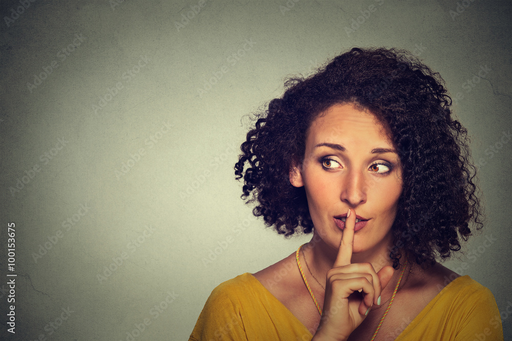 secretive woman placing finger on lips asking shh, quiet, silence ...