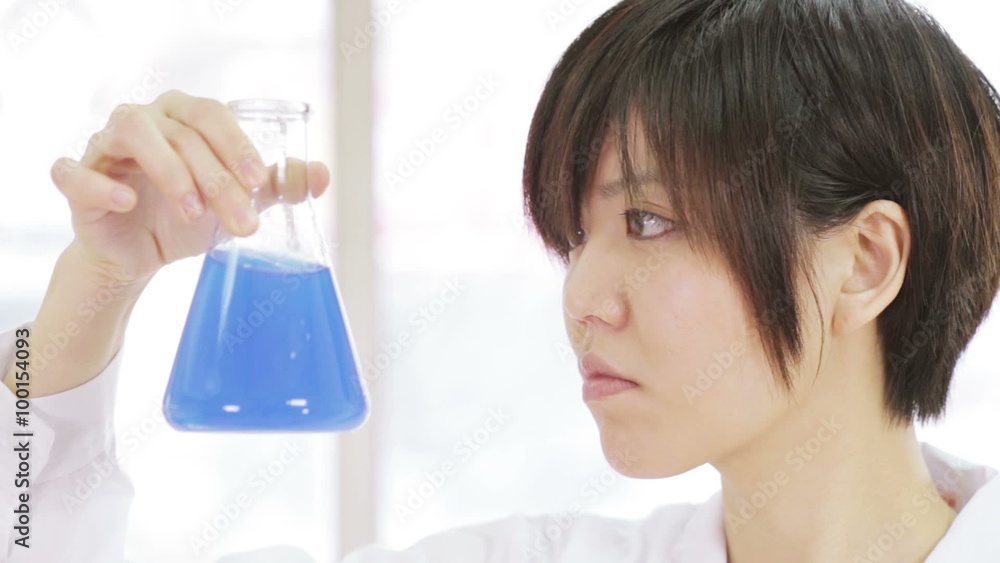 Asian scientist inspecting erlenmeyer flask