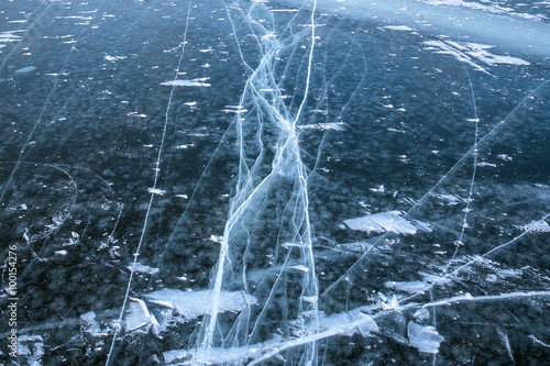 Deep cracks in the frozen water of the sea bay