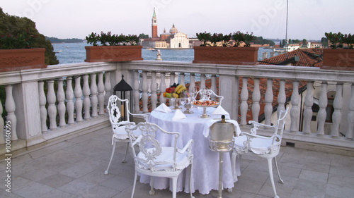 Dolly shot of a table and chairs on a deck in Venice.