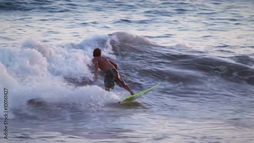 Young male surfer surfing along the coast in Costa Rica