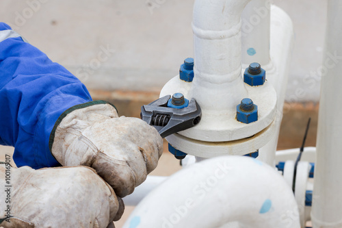 Close-up image of human hand fixing and stop leak flange by wrench in oil and gas process