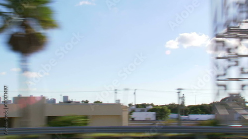 Palm trees and buildings in Miami seen from driving on the freeway. photo