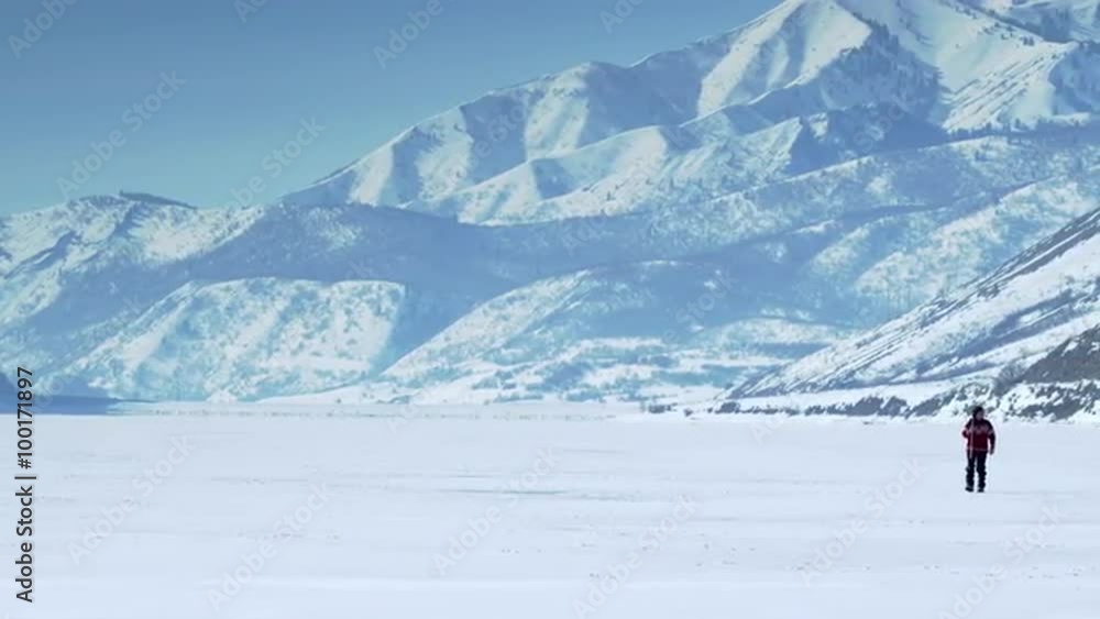 Person walking through the snow in the distance. Person walking through the snow in the distance.