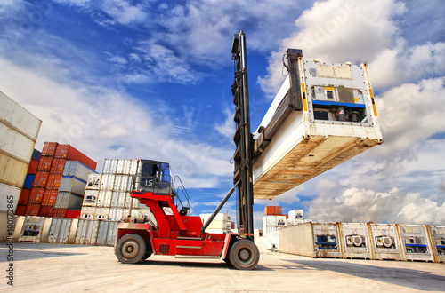 forklift handling the reefer container box at dockyard photo