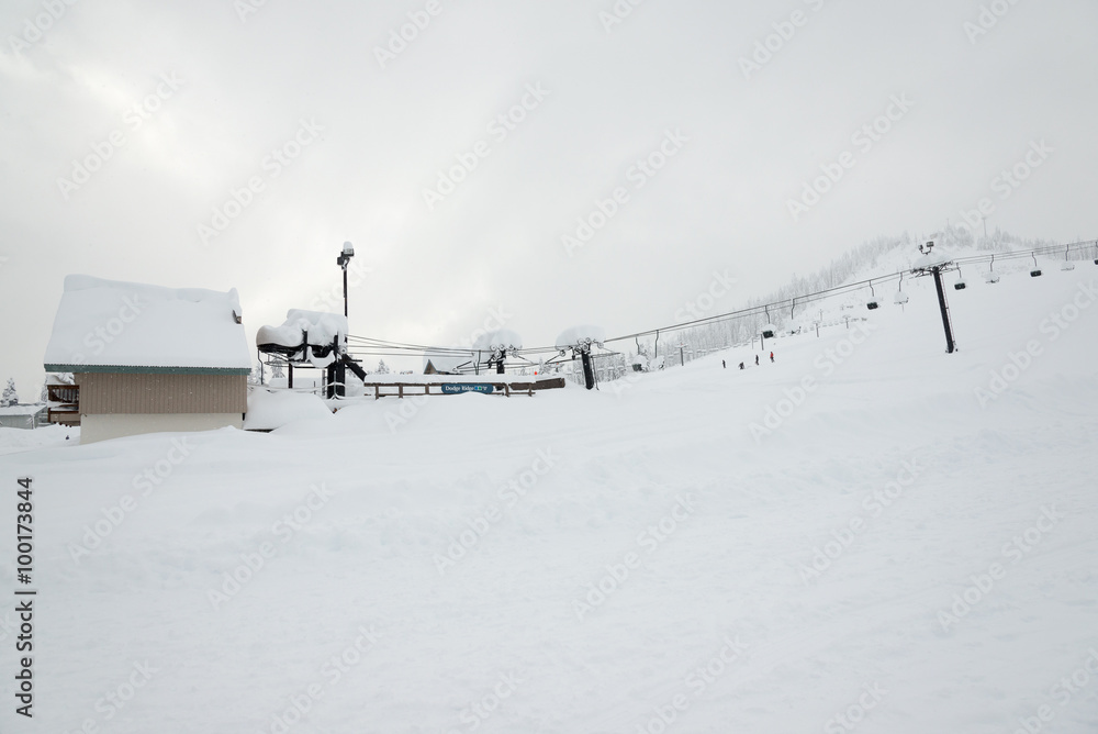 Obraz premium scene of ski lift with seats over the mountain and paths from skier.
