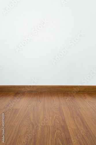 empty room with brown wood laminate floor and white mortar wall © sutichak