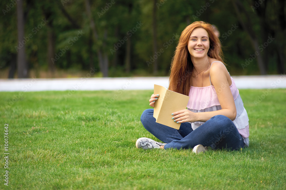 woman lying on a lawn with a diary