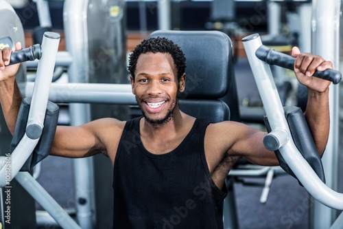 Smiling man using exercise machine 
