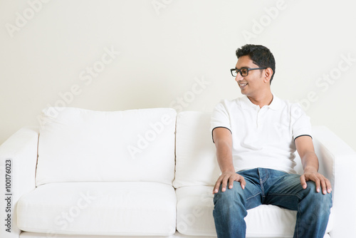Lonely single Asian man sitting on couch and looking at side © WONG SZE FEI