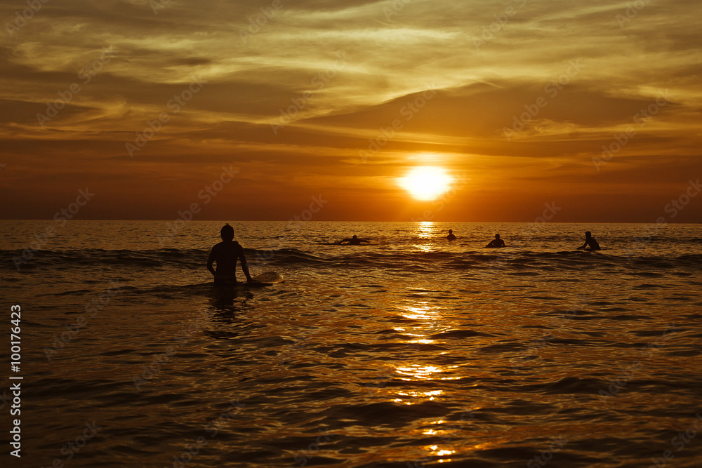 Surfing at Sunset. Young Man Riding Wave at Sunset. Outdoor Active Lifestyle