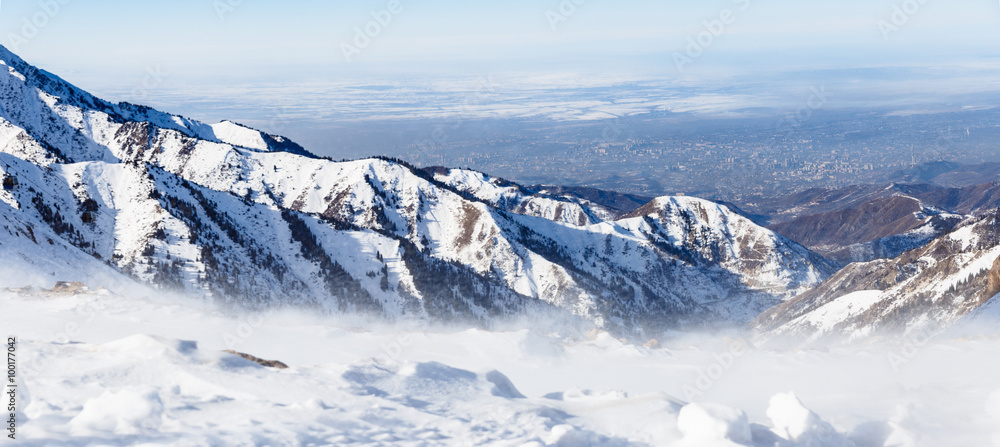 Mountains under the snow in winter. Panorama of snow mountain range landscape with blue sky.
