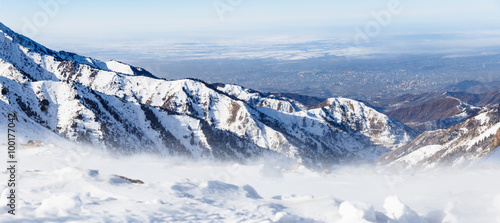 Mountains under the snow in winter. Panorama of snow mountain range landscape with blue sky. © kulikovan