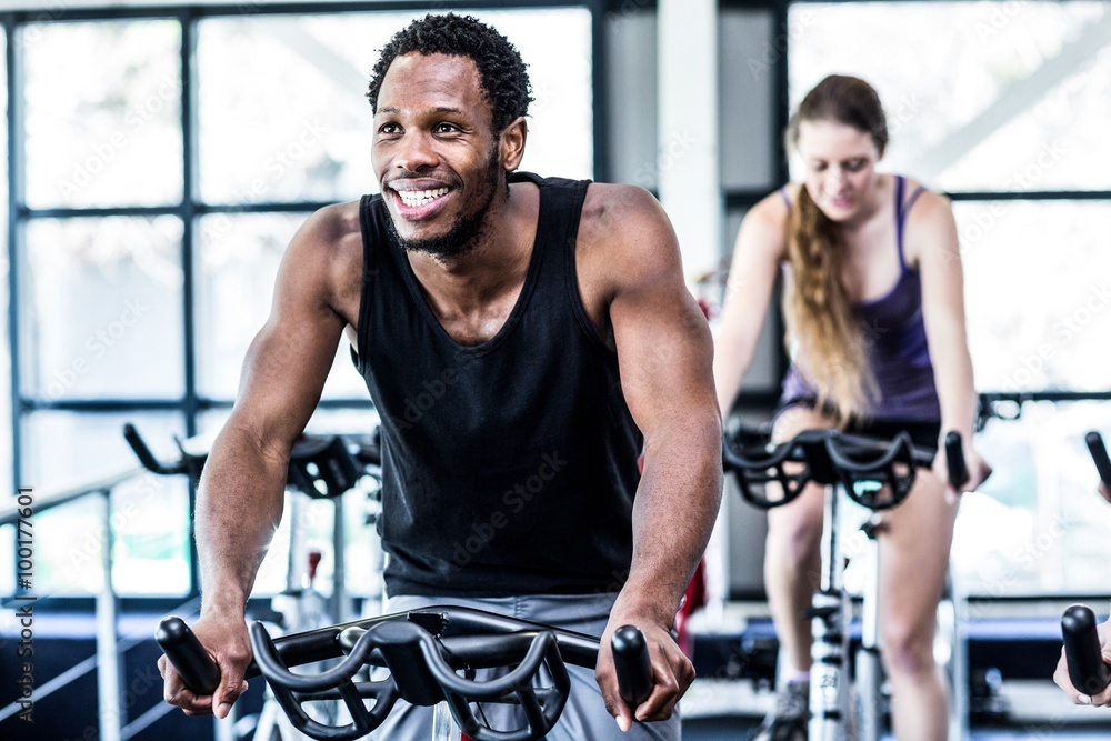 Naklejka premium Fit man working out at spinning class