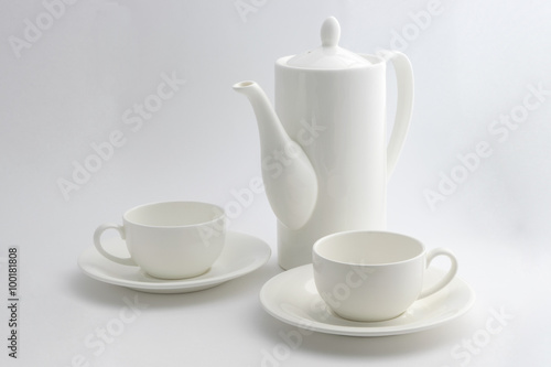 A white coffee pot and a cup