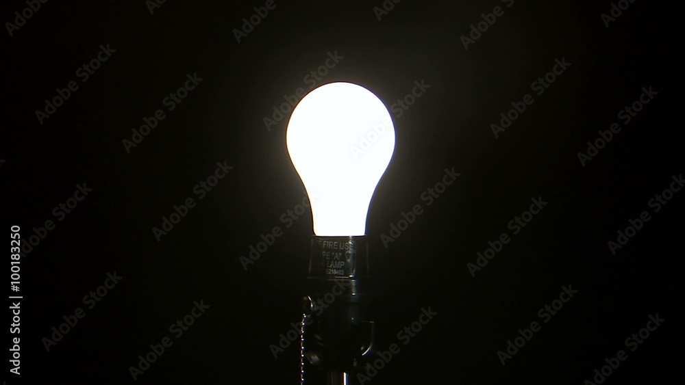Light bulb turning on against a black background. Light bulb turning on against a black background.