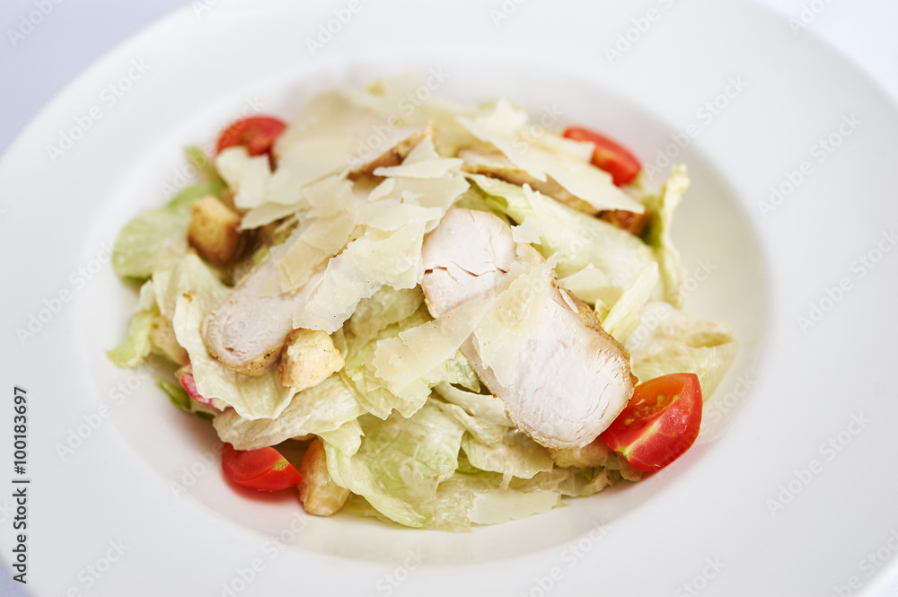 Caesar salad with chicken on white plate studio shot Caesar salad with chicken on white plate studio shot
