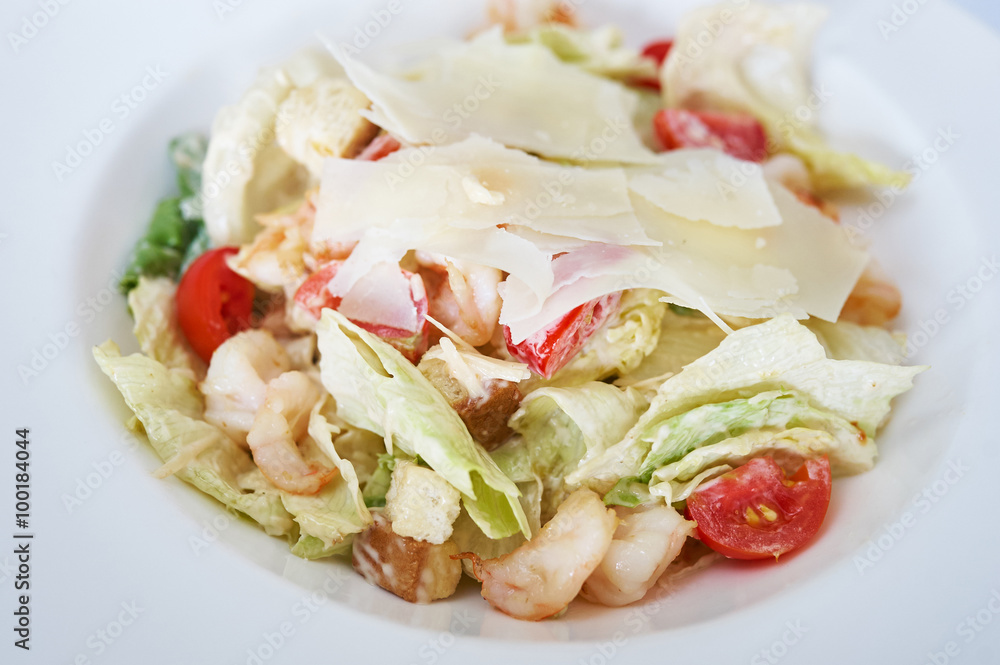 Caesar salad with shrimps on white plate studio shot Caesar salad with shrimps on white plate studio shot