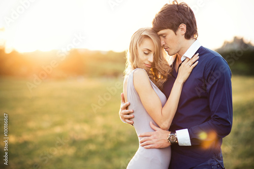 Young couple in love, outdoors portrait at the sunset. Romantic time in the sunset garden