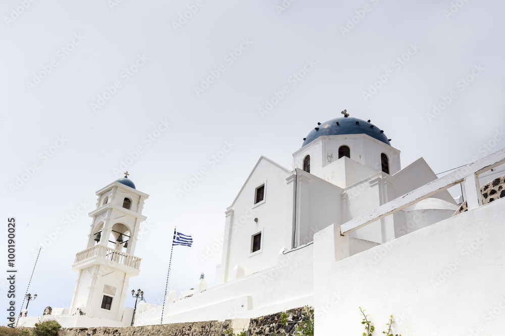 Traditional Greek white church arch with cross and bells in Sant