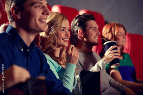 happy friends watching movie in theater