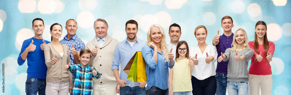 happy people with shopping bags showing thumbs up
