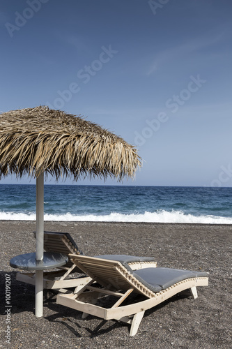 view of Perissa beach on the Greek island of Santorini with sunb