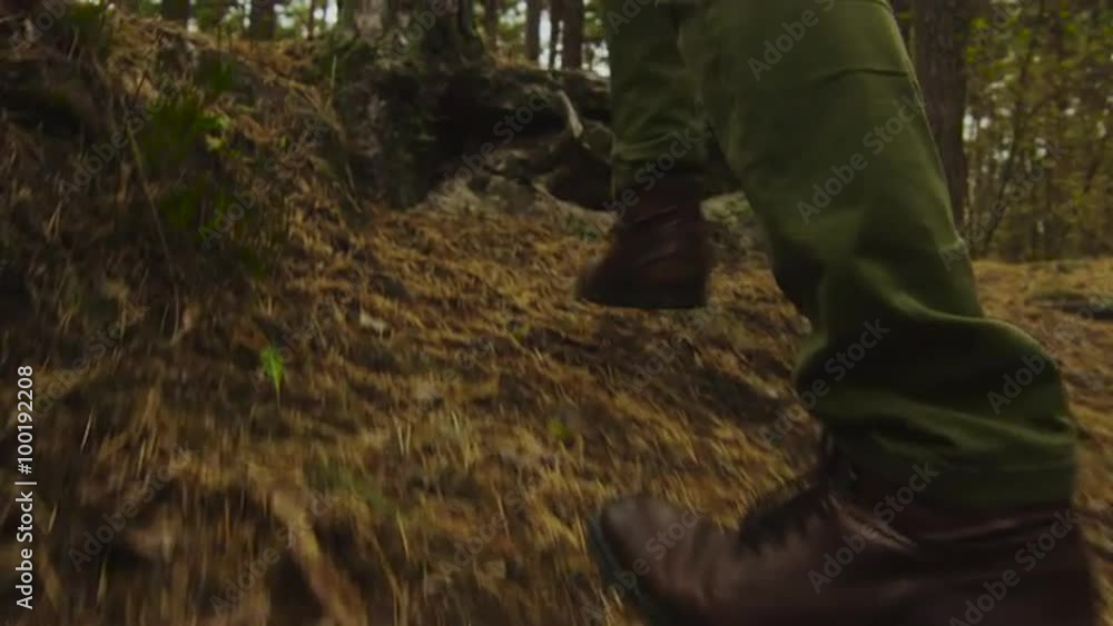 Hiker in close-up slow motion leg shot walks uphill in the forest in autumn. Shot on RED Cinema Camera. Hiker in close-up slow motion leg shot walks uphill in the forest in autumn. Shot on RED Cinema Camera.