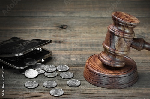 Gavel, Empty Purse, Coins, And Old Book On Wooden Table