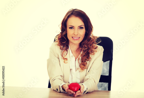 Business woman holding red heart.