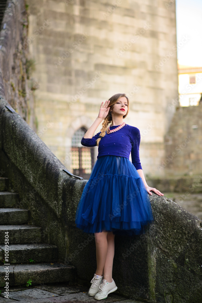 girl posing in blue dress standing on stone stairs