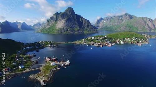 Aerial footage of fishing town Reine on Lofoten islands in Norway, popular tourist destination on sunny summer day. Aerial 4k Ultra HD.
