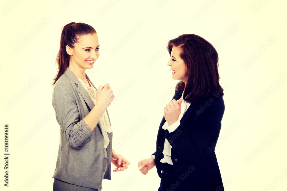 Happy two businesswomen making fists. Happy two businesswomen making fists.