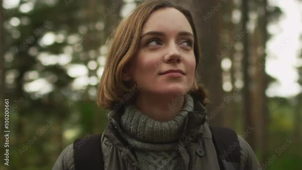Brunette woman in dark autumn coat is standing in a forest and looking around. Shot on RED Cinema Camera. Brunette woman in dark autumn coat is standing in a forest and looking around. Shot on RED Cinema Camera.