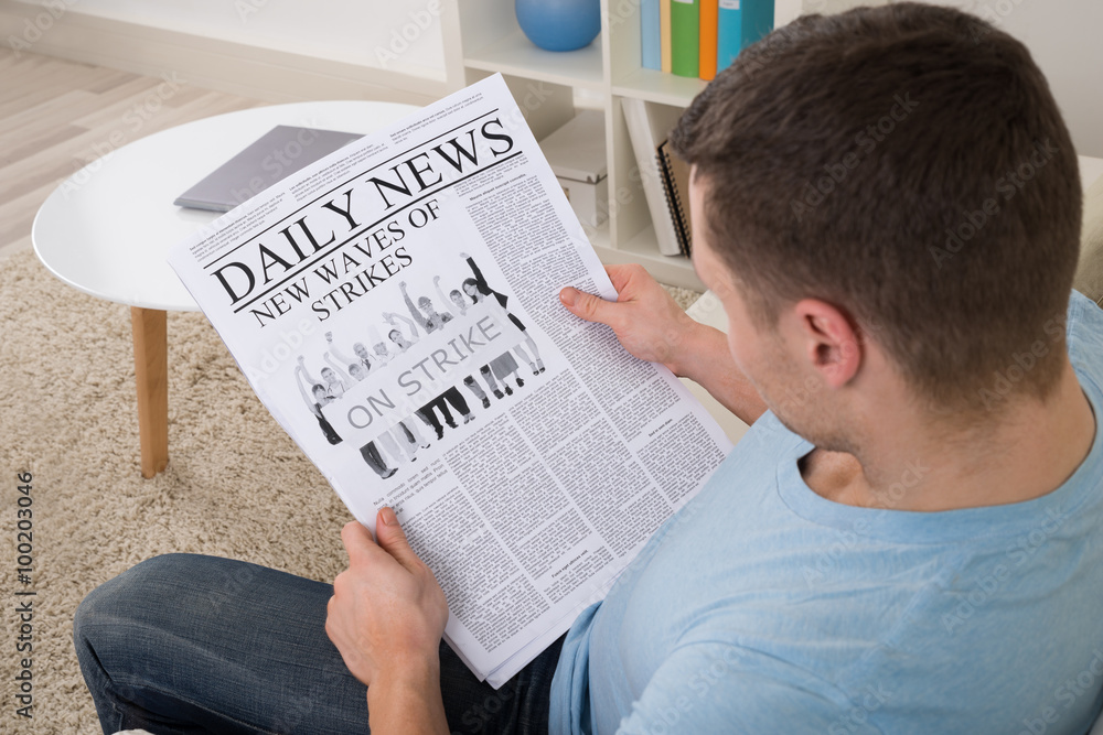 Naklejka premium Man Reading News On Newspaper At Home