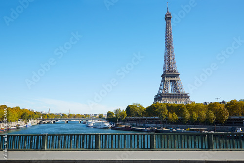Eiffel tower and empty sidewalk bridge on Seine river in autumn