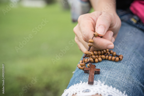 Woman hands praying with a rosary