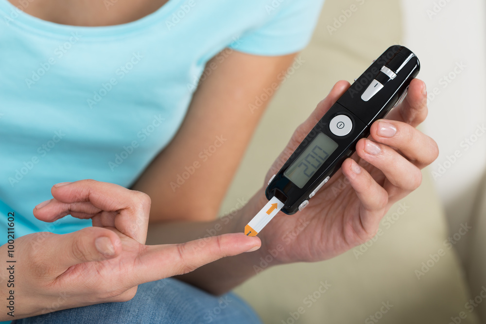 Woman Checking Blood Sugar Level Woman Checking Blood Sugar Level