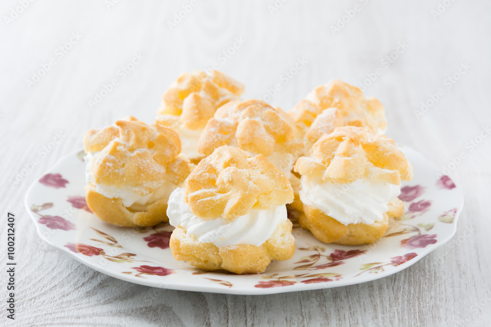 Fresh profiteroles with cream on plate
Fresh profiteroles with cream on plate