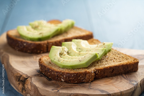 toasted rye bread with sliced avocado and herbs