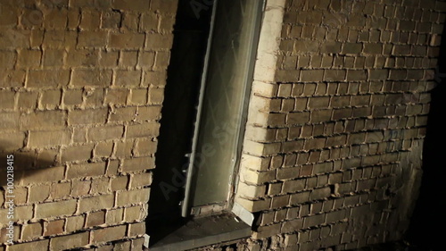 Scary place, grated window in old brick wall, abandoned building, criminal lair