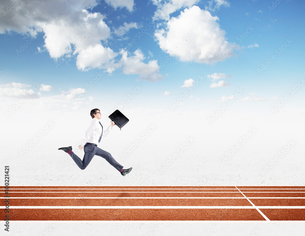 A young businessman running forward with a black folder in hand approaching the finish line. Blue sky at the background. Concept of competition. A young businessman running forward with a black folder in hand approaching the finish line. Blue sky at the background. Concept of competition.