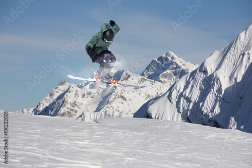 Flying skier on mountains. Extreme sport.