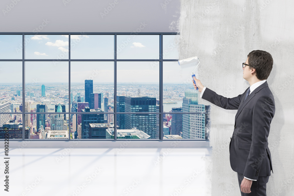 Fototapeta premium Businessman covering office view with paint
