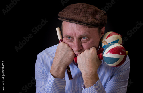 Portrait of sad mature musician with Ukrainian woodwind instrument sopilka and maracas photo