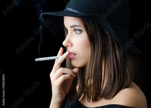 Portrait of the beautiful elegant girl smoking cigarette