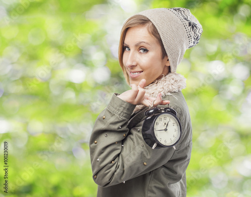 beautiful young woman holding an alarm clock