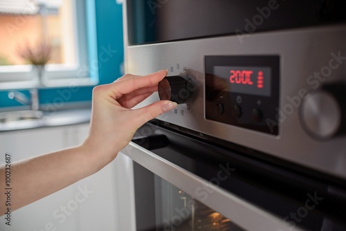 Woman regulates the temperature of the oven photo